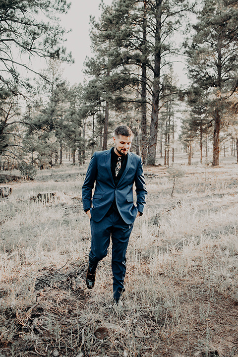  the groom in a blue suit with bow tie 