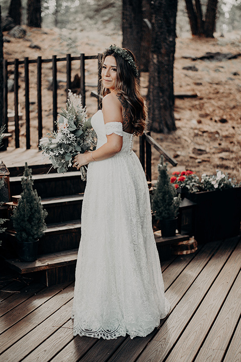  bride in a bohemian gown with an off the shoulder detail and a floral crown 