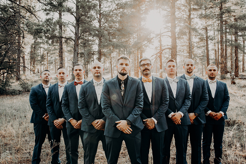  groom and groomsmen in dark blue suits with bow ties 