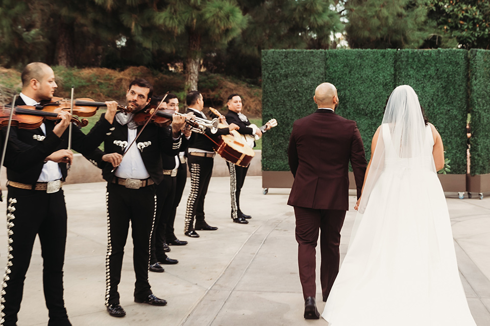  couple walking away from wedding with band 