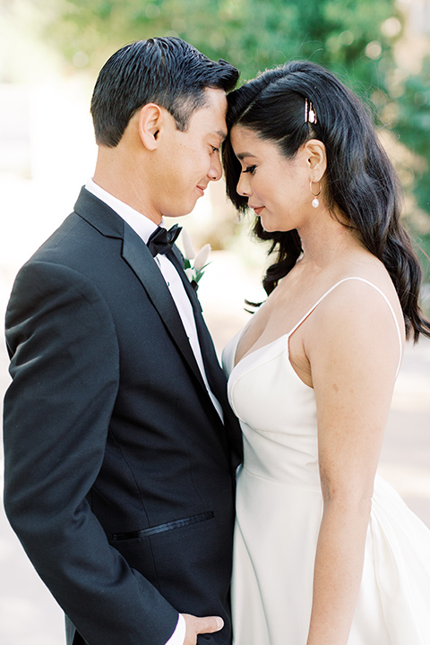  bride in a white modern ballgown with pockets and a low cut neckline and bridesmaids in neutral gowns