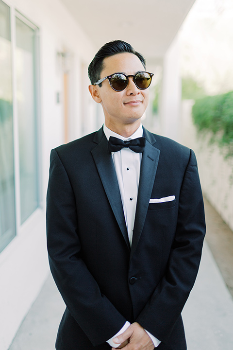  groom in a black tuxedo with a black bow tie