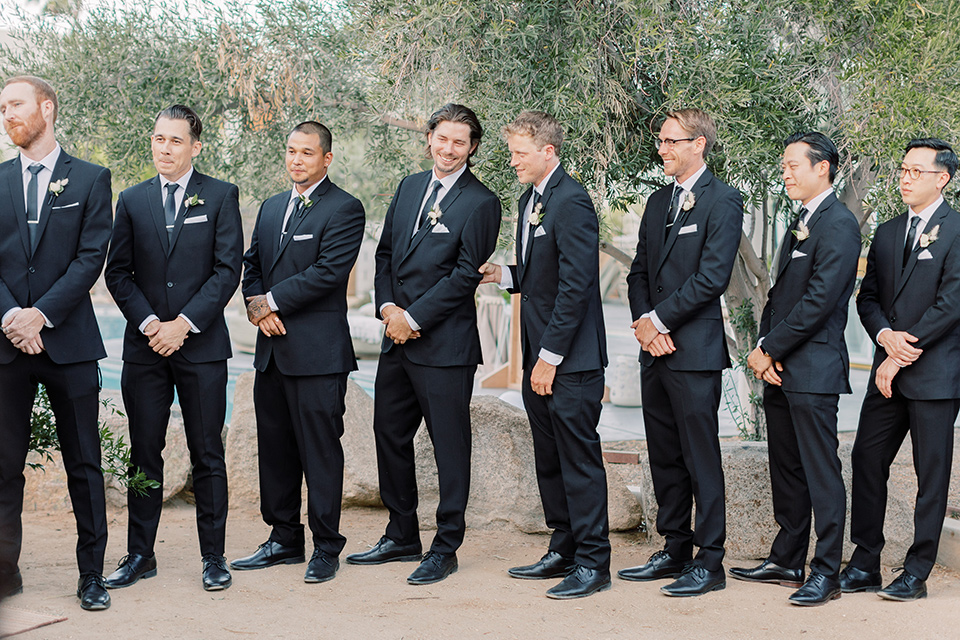  groom and groomsmen in black tuxedos and black bow ties