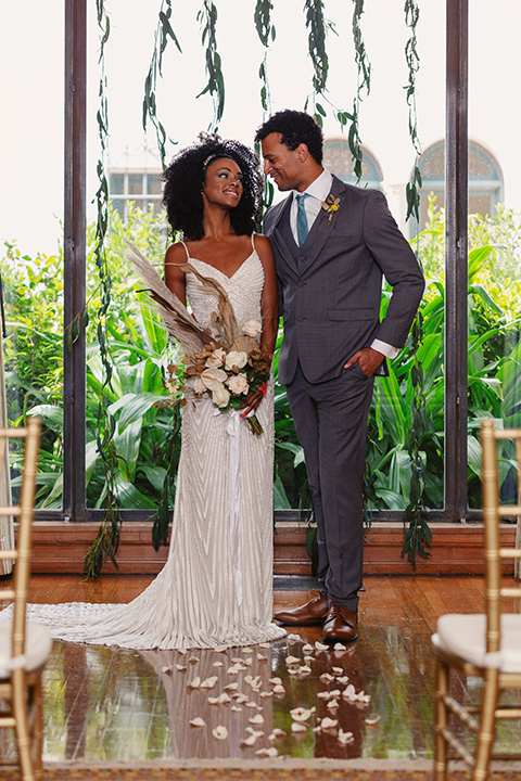  bride in a white lace formfitting gown with a V-neckline, and the groom in a café brown suit a dusty teal long tie 