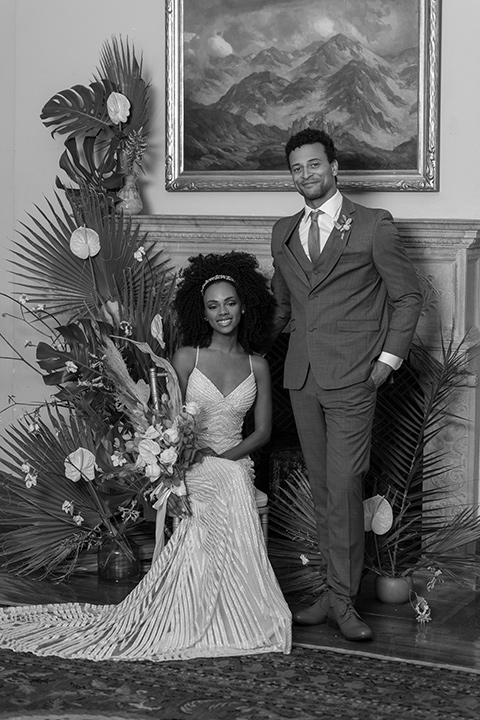  bride in a white lace formfitting gown with a V-neckline, and the groom in a café brown suit a dusty teal long tie 