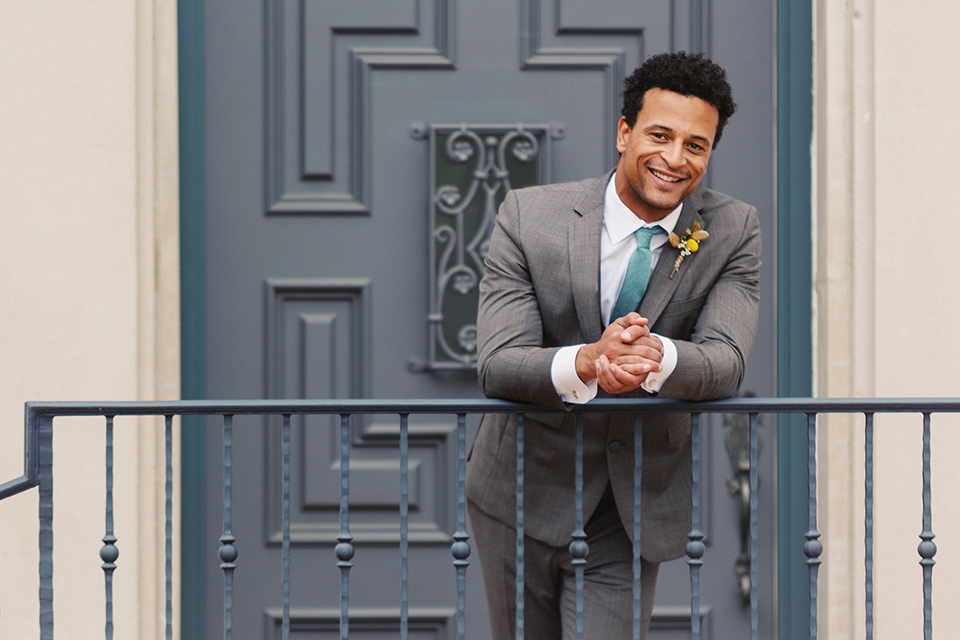  the groom in a café brown suit a dusty teal long tie 