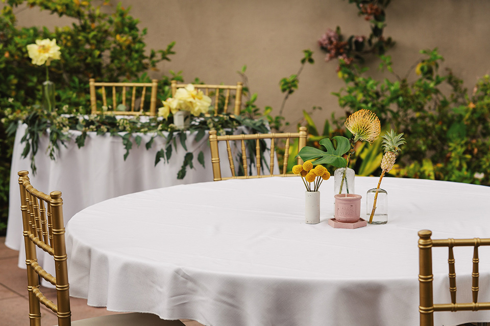  white table linens with gold chairs 