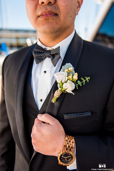 the groom in a black tuxedo with a black bow tie 