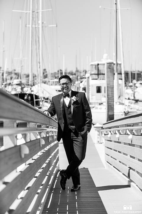  the groom in a black tuxedo with a black bow tie 