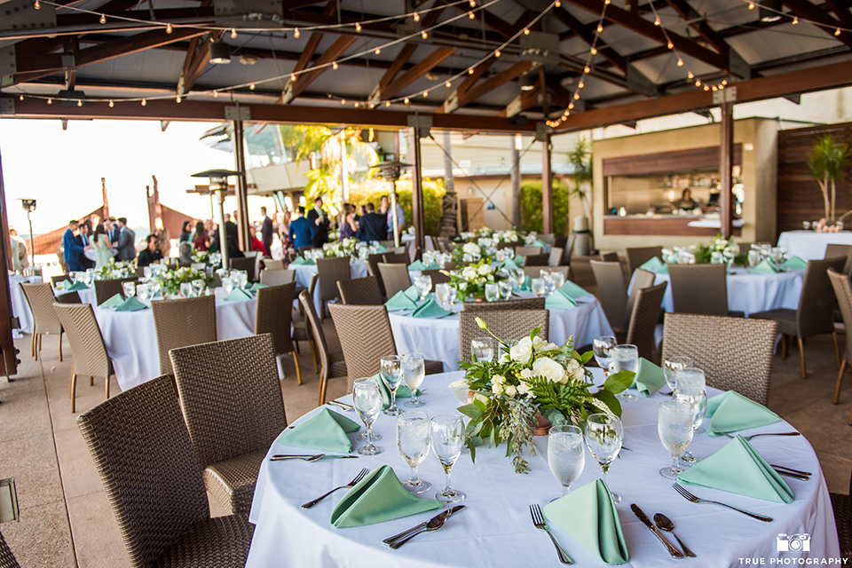  white table linens with mint green and gold details