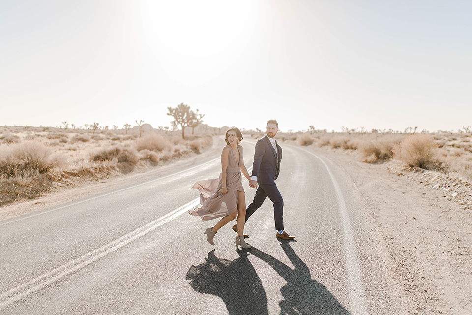  bride in a taupe gown with ankle boots and straps, the groom in a cobalt blue suit with a neutral colored tie 