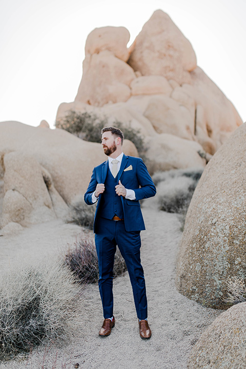  groom in a cobalt blue suit and a neutral colored long tie 