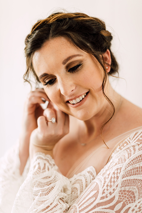 bride in a bohemian style gown with lace, a high neckline, and flutter sleeves