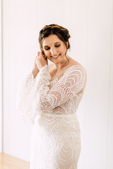 bride in a bohemian style gown with lace, a high neckline, and flutter sleeves