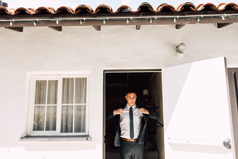 groom putting on his jacket