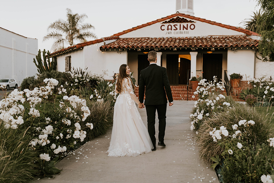  bride in a flowing ballgown and the groom in a black suit 