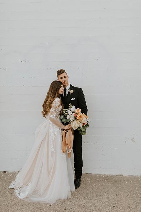  bride in a flowing ballgown and the groom in a black suit