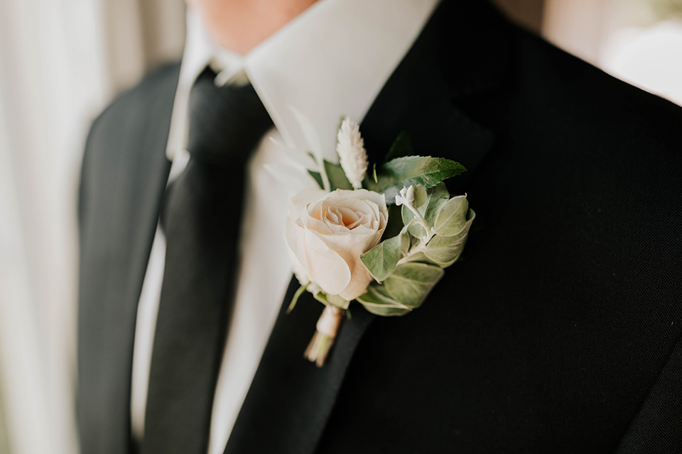  bride in a flowing ballgown and the groom in a black suit, the bridesmaids in neutral colors and the groomsmen in black suits and long ties 