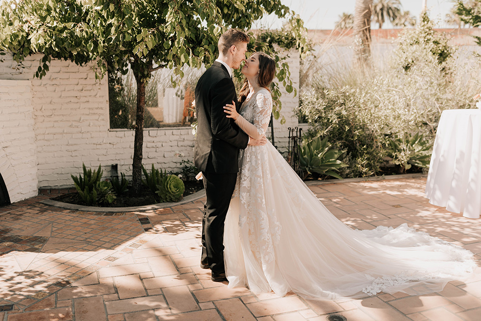  bride in a flowing ballgown and the groom in a black suit, 