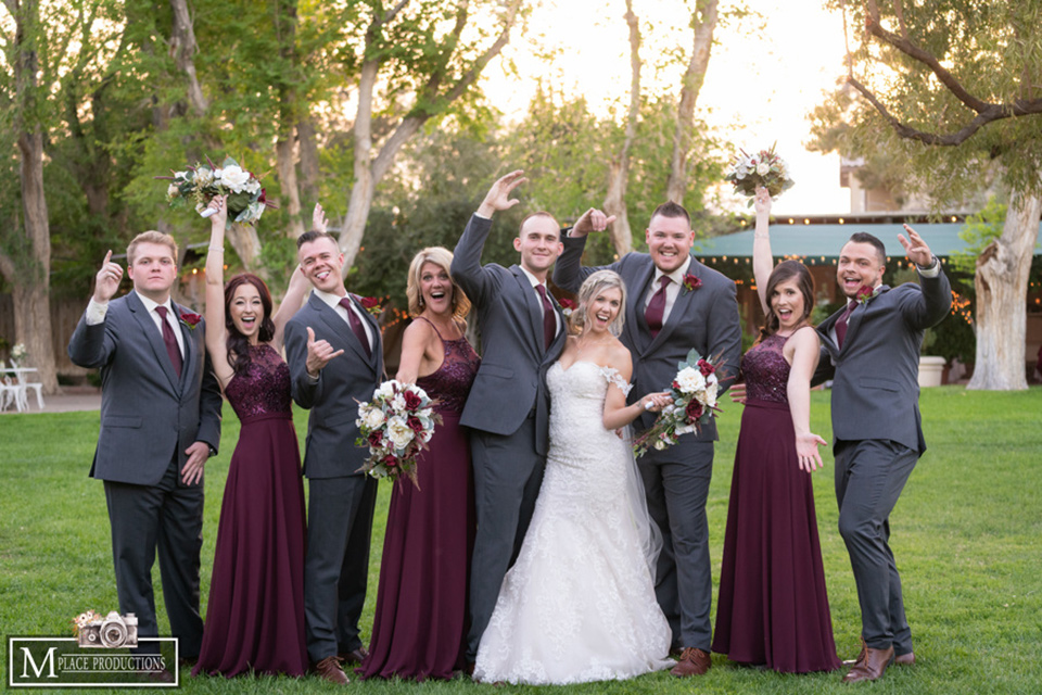  bride in a white lace gown with an off the shoulder detail and long veil and the groom in a dark grey suit 