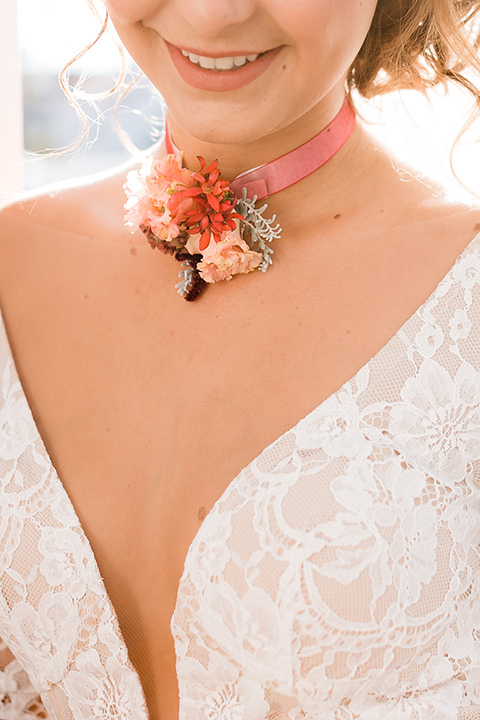 bride in a Spanish lace formfitting gown with sleeves and a floral necklace