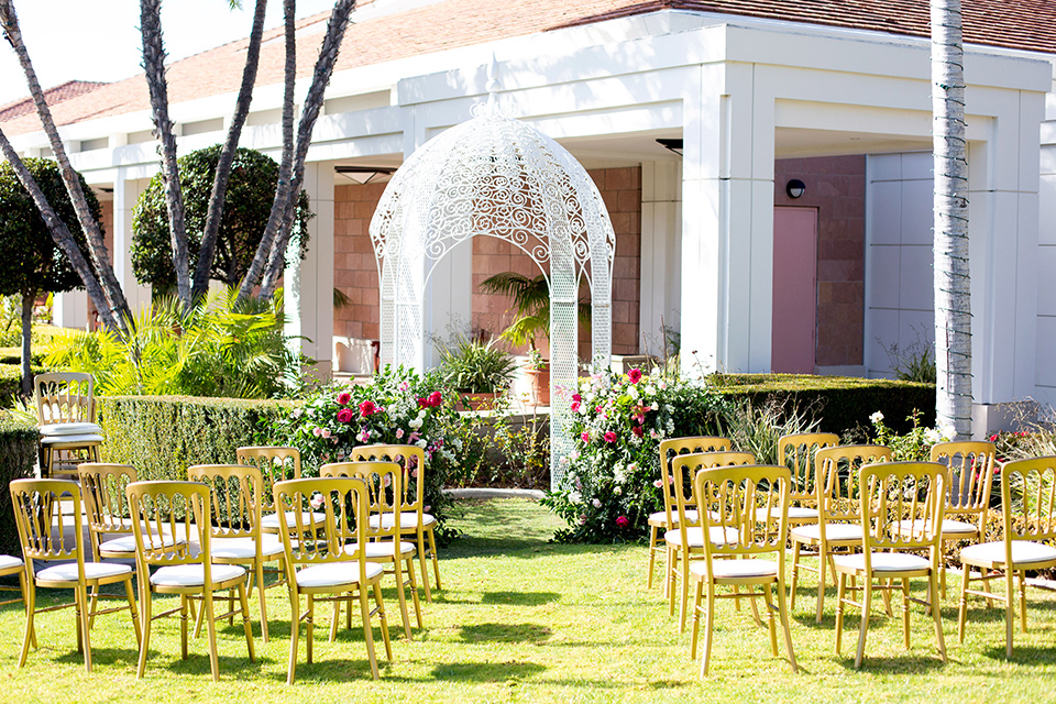  ceremony space with gold chairs and white arch