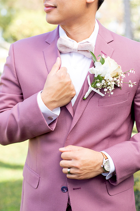  the groom in a rose pink suit with a pink bow tie