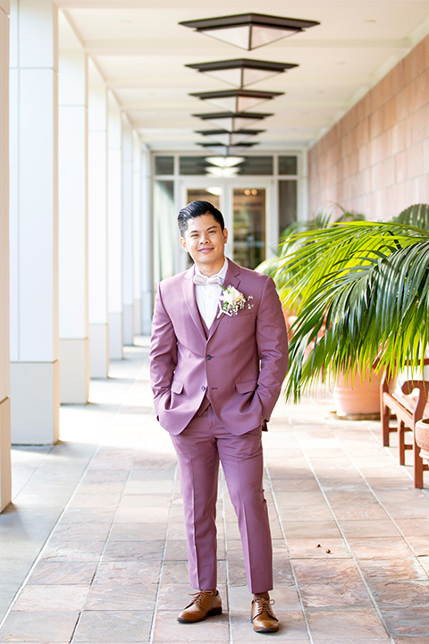  the groom in a rose pink suit and a pink bow tie