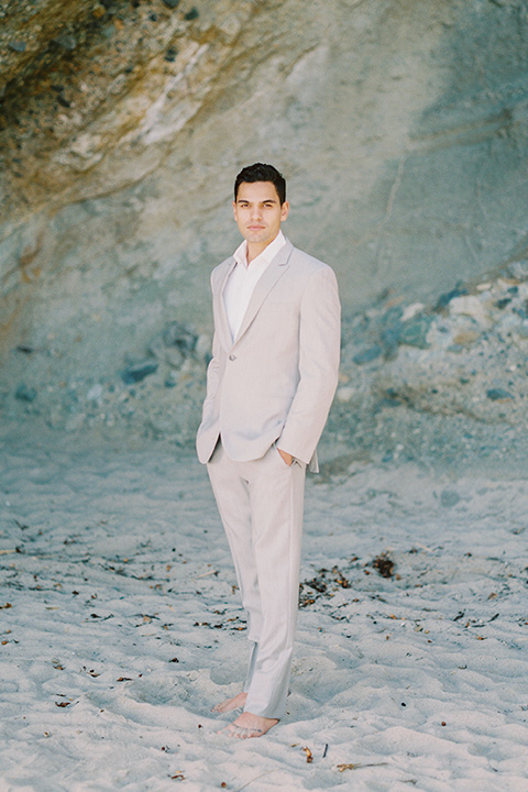groom in a light grey suit with a white shirt and no tie