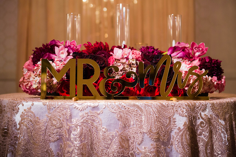  sweetheart table with rose gold linens and pink and purple flowers and gold Mr. and Mrs. lettering 