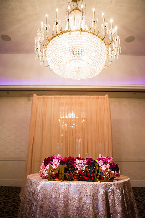  sweetheart table with rose gold linens and pink and purple flowers and gold Mr. and Mrs. lettering