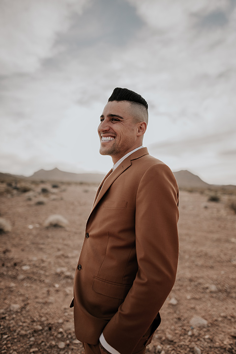  groom in a caramel rust suit color with a brown long tie 