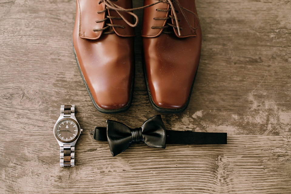  brown shoes with a black bow tie on it