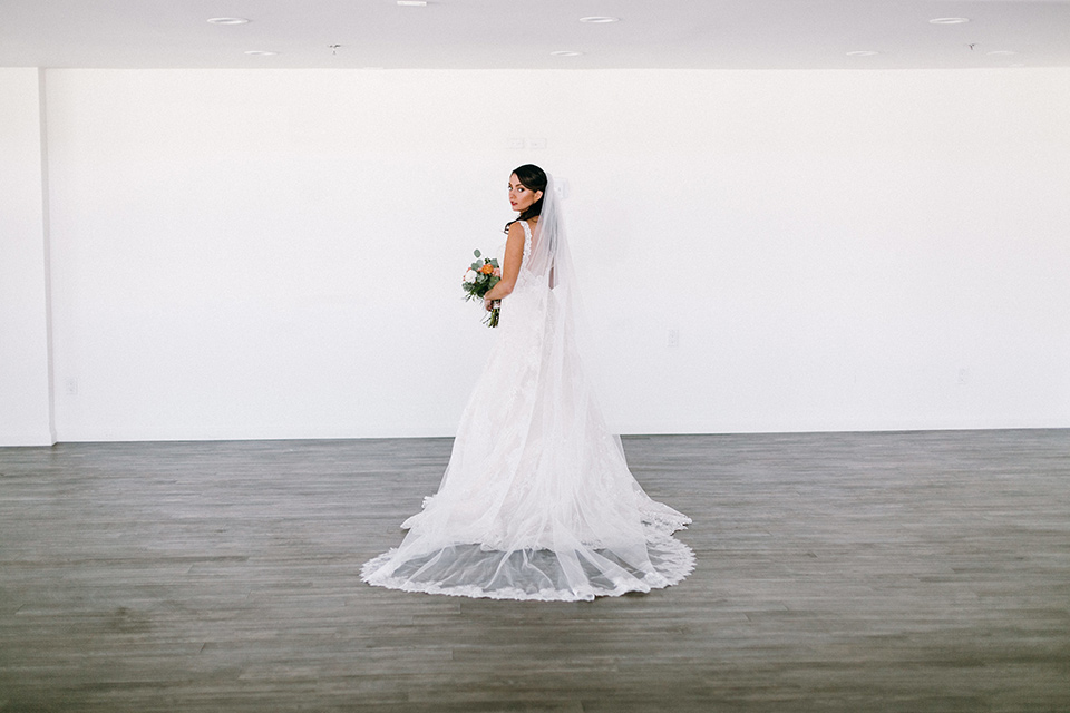  bride in a lace white gown with a long veil 