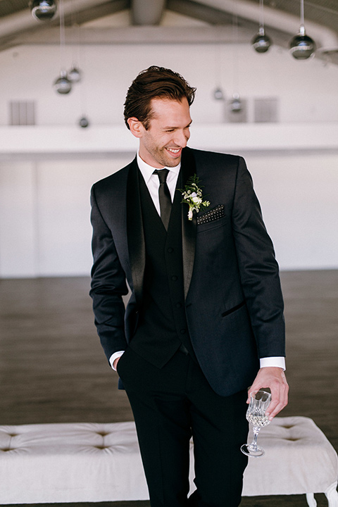  the groomsmen in a navy shawl lapel tuxedo with black bow ties