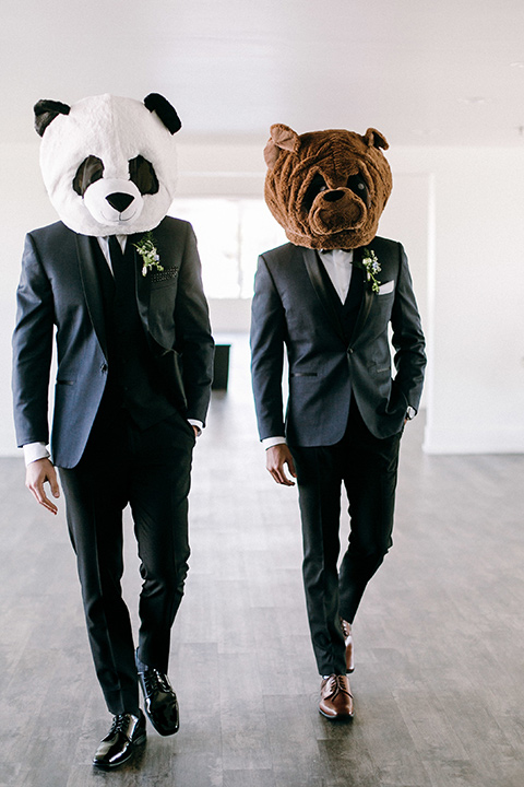  groomsmen in a navy shawl lapel tuxedo with black bow ties and white pocketsquare wearing animal heads 