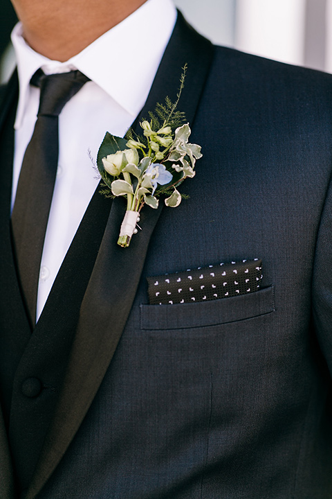  groom in a navy shawl lapel tuxedo with black bow ties and white pocketsquare 