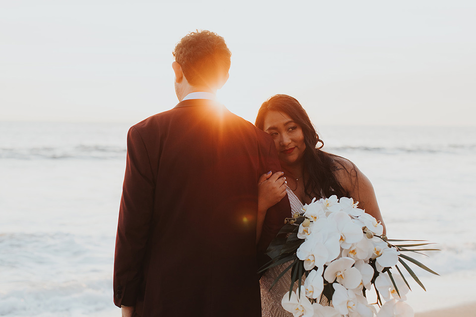  bride in a cultural Burmese gown, the groom in a burgundy tuxedo with a black shawl