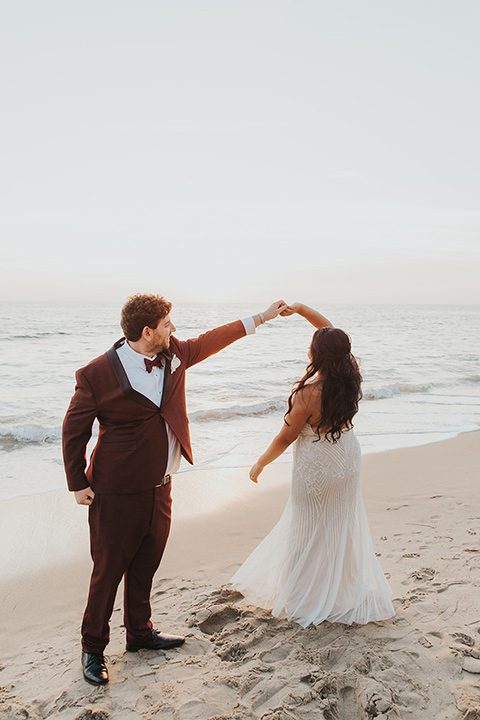  bride in a white lace gown and the groom in a burgundy tuxedo 