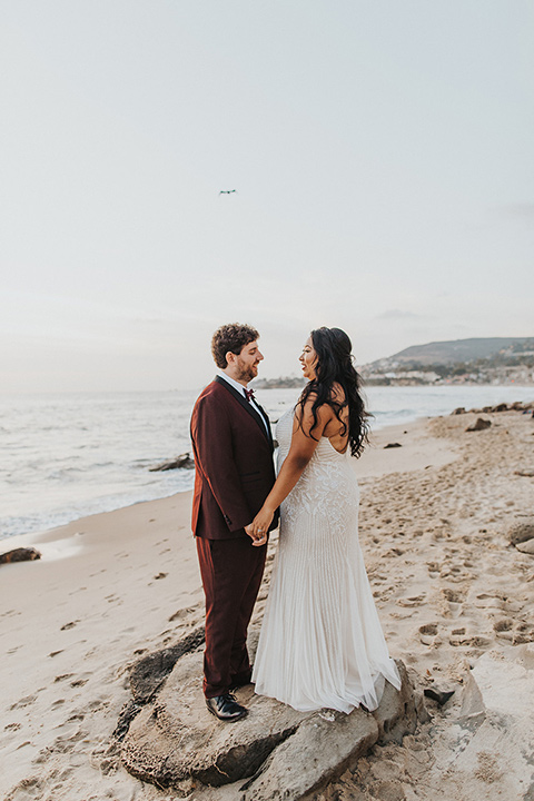  bride in a white lace gown and the groom in a burgundy tuxedo 