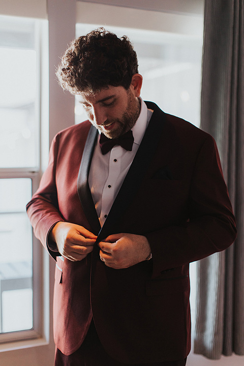  bride in a white lace gown and the groom in a burgundy tuxedo 