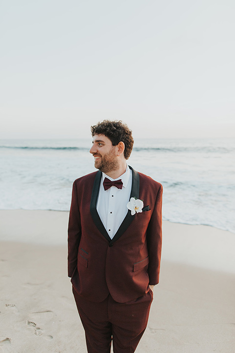  bride in a white lace gown and the groom in a burgundy tuxedo 