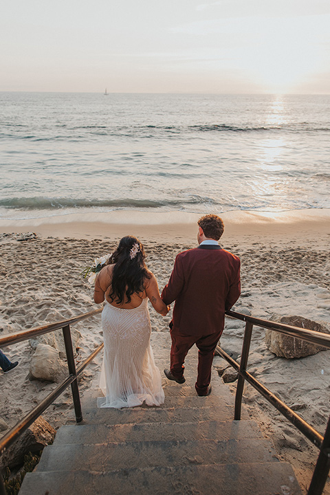  bride in a white lace gown and the groom in a burgundy tuxedo 