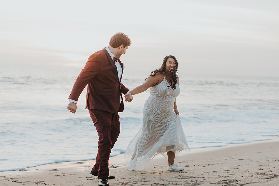  bride in a white lace gown, the groom in a burgundy tuxedo with a black shawl