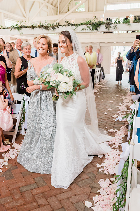  bride in a white modern lace gown with a cathedral veil and bridesmaids in blush toned gowns