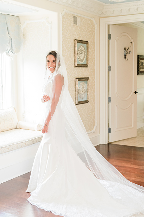  bride in a white modern lace gown with a cathedral veil 