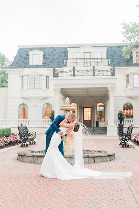  bride in a white modern lace gown with a cathedral veil and the groom in a cobalt blue suit