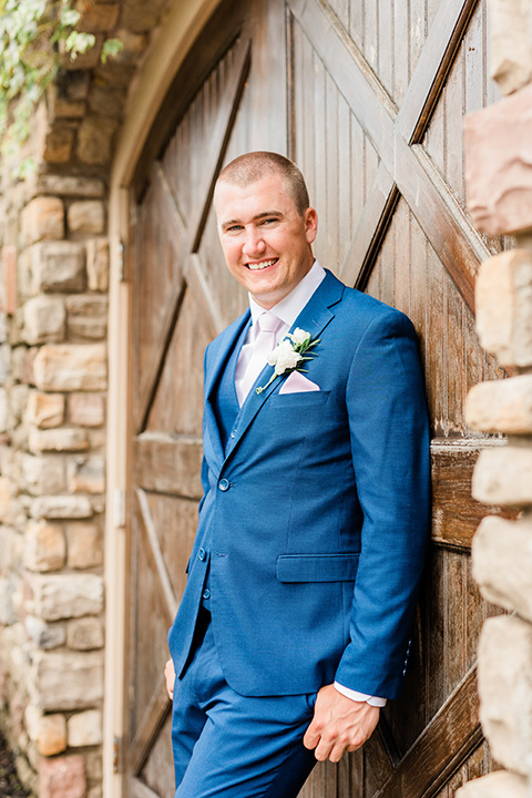  the bridesmaids in blush toned gowns and the groom in  a cobalt blue suit