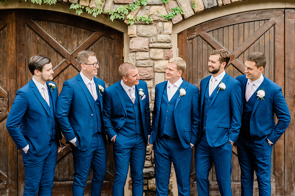 the groom in a cobalt blue suit and the groomsmen in cobalt blue suits