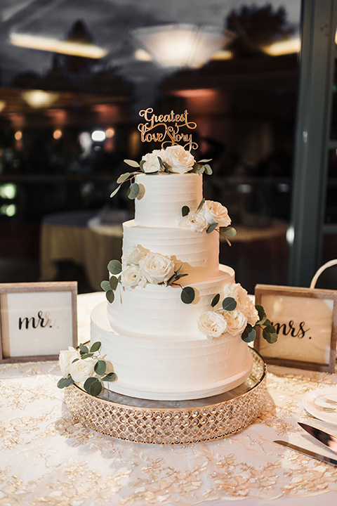  white three tiered cake with white flowers 